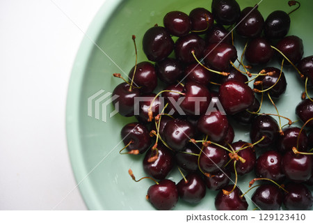 Ripe cherries in a green bowl. Ripe cherries in a basin. 129123410
