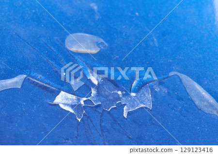 Close up of cracked blue paint surface with fragmented patterns and peeling Close up of cracked blue paint surface with fragmented patterns and peeling 129123416