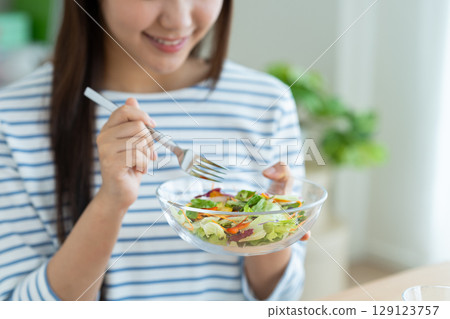 A young woman eating a salad A young woman eating a salad 129123757