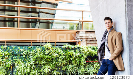 Stylish young man in coat and scarf outdoors Stylish young man in coat and scarf outdoors 129123973
