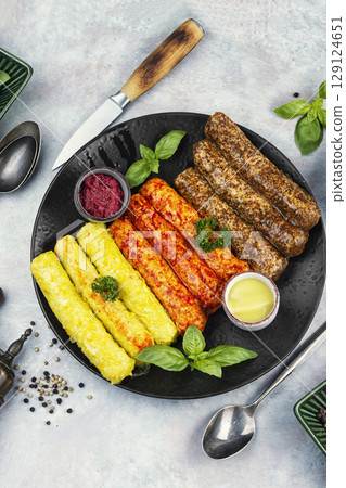 Fresh uncooked sausages on a plate. Fresh uncooked sausages on a plate. 129124651