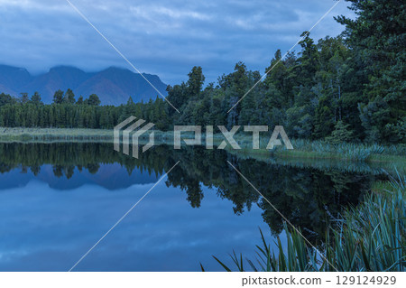 Mount Cook in clouds as seen from Lake Matheson on the West Coast of New Zealand Mount Cook in clouds as seen from Lake Matheson on the West Coast of New Zealand 129124929