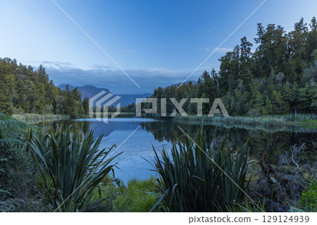 Mount Cook in clouds as seen from Lake Matheson on the West Coast of New Zealand 129124939