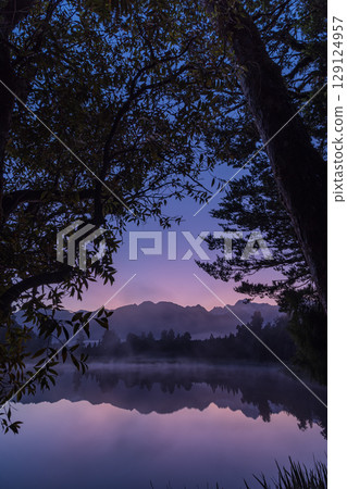 Mount Cook and the sunrise seen from Lake Matheson in the early morning mist, New Zealand Mount Cook and the sunrise seen from Lake Matheson in the early morning mist, New Zealand 129124957