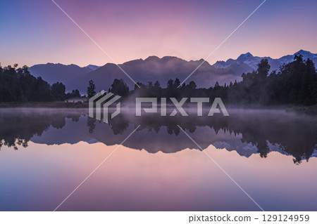 Mount Cook and the sunrise seen from Lake Matheson in the early morning mist, New Zealand Mount Cook and the sunrise seen from Lake Matheson in the early morning mist, New Zealand 129124959
