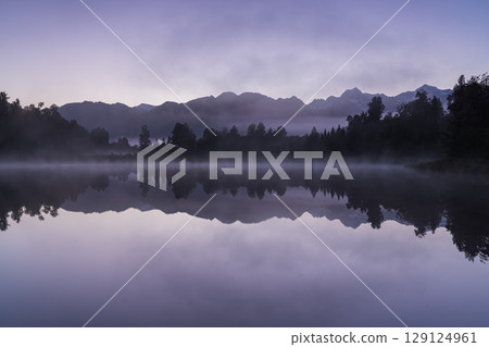 Mount Cook and the sunrise seen from Lake Matheson in the early morning mist, New Zealand 129124961