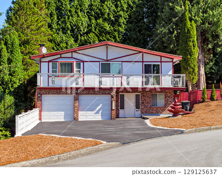 Family residential house with double garage and tall trees on the back yard Family residential house with double garage and tall trees on the back yard 129125637