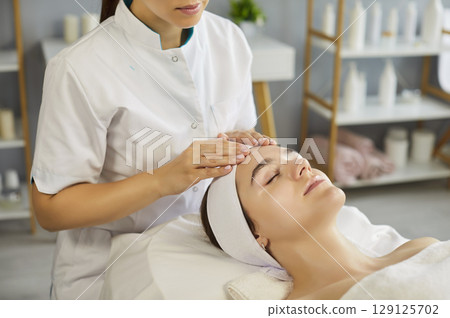 Facial massage by beautician in modern spa clinic 129125702