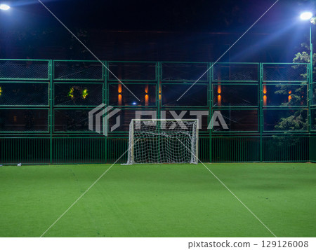 Football ground in the evening. Artificial lawn. Available infrastructure. Empty sports ground. Football game concept. Sports mesh. Entertainment in the park. Under the lanterns Football ground in the evening. Artificial lawn. Available infrastructure. Empty sports ground. Football game concept. Sports mesh. Entertainment in the park. Under the lanterns 129126008
