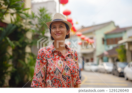 woman exploring streets of George Town, during Chinese New Year. 129126040