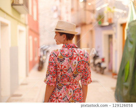 Woman strolls through colorful streets of Spanish coastal town Woman strolls through colorful streets of Spanish coastal town 129126058
