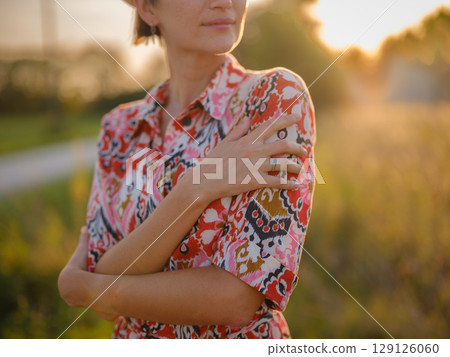 boho chic woman in a floral dress in European countryside 129126060