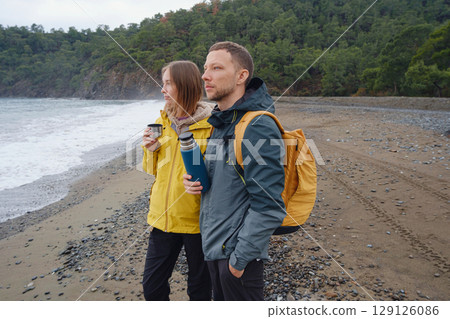 Couple drinks tea by winter sea shore 129126086