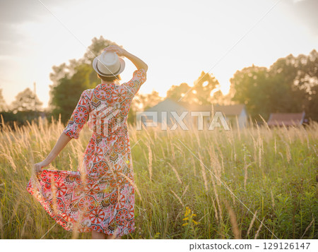 boho chic woman in a floral dress in European countryside 129126147