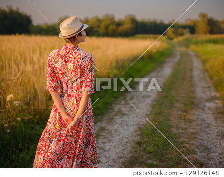 boho chic woman in a floral dress in European countryside boho chic woman in a floral dress in European countryside 129126148
