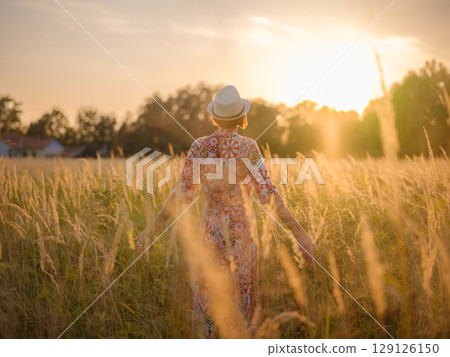 boho chic woman in a floral dress in European countryside 129126150