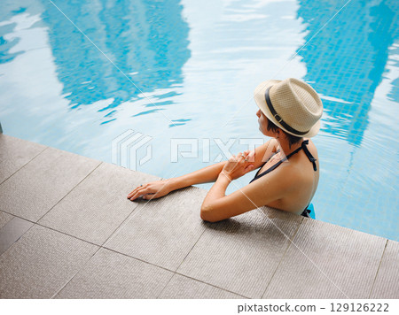 Young woman relaxing by the pool at a Kuala Lumpur hotel Young woman relaxing by the pool at a Kuala Lumpur hotel 129126222