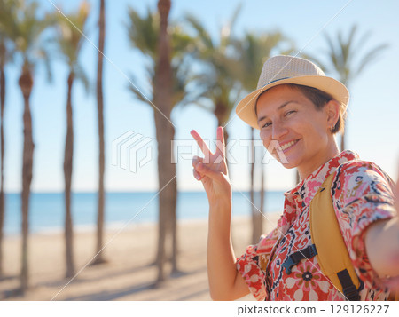 Woman strolls through colorful streets of Spanish coastal town 129126227
