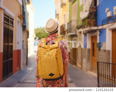 Woman strolls through colorful streets of Spanish coastal town Woman strolls through colorful streets of Spanish coastal town 129126228