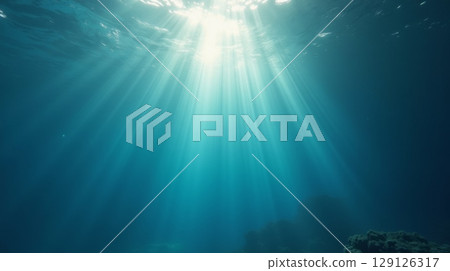 Sun rays penetrating deep blue ocean water. Underwater light beams creating mystical marine atmosphere. Nature and sea life background 129126317