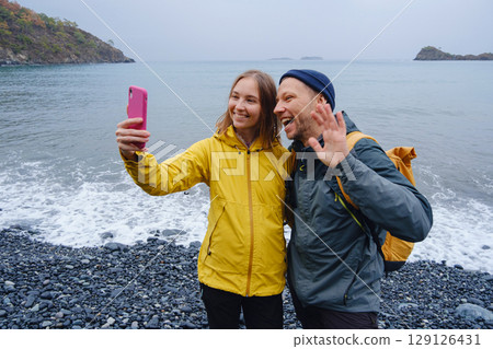 Couple taking selfie on beach in Winter 129126431