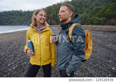 Couple drinks tea by winter sea shore 129126439