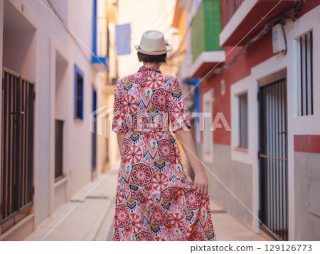 Woman strolls through colorful streets of Spanish coastal town 129126773