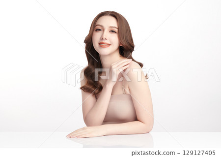 A beautiful young Asian woman with clean, fresh skin against a white background. Skincare, facial treatment, cosmetology, beauty, and spa. An elegant portrait of an Asian woman. 129127405