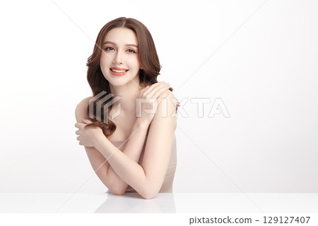 A beautiful young Asian woman with clean, fresh skin against a white background. Skincare, facial treatment, cosmetology, beauty, and spa. An elegant portrait of an Asian woman. 129127407