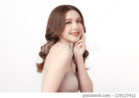 A beautiful young Asian woman with clean, fresh skin against a white background. Skincare, facial treatment, cosmetology, beauty, and spa. An elegant portrait of an Asian woman. 129127412