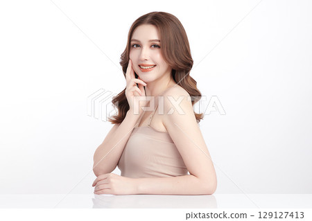 A beautiful young Asian woman with clean, fresh skin against a white background. Skincare, facial treatment, cosmetology, beauty, and spa. An elegant portrait of an Asian woman. 129127413