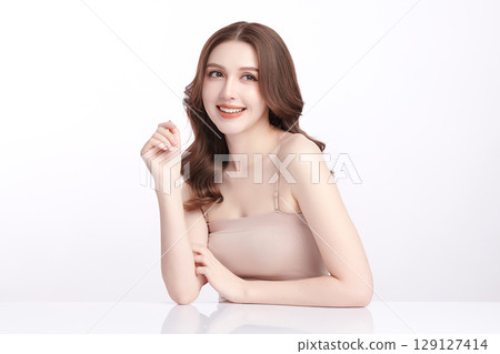 A beautiful young Asian woman with clean, fresh skin against a white background. Skincare, facial treatment, cosmetology, beauty, and spa. An elegant portrait of an Asian woman. 129127414