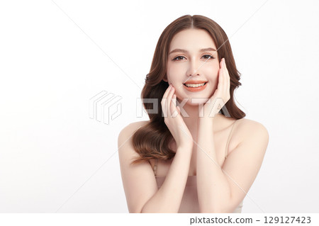 A beautiful young Asian woman with clean, fresh skin against a white background. Skincare, facial treatment, cosmetology, beauty, and spa. An elegant portrait of an Asian woman. 129127423