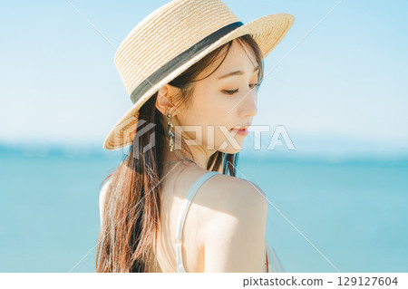 戴著草帽的女人，背景是海和藍天 129127604