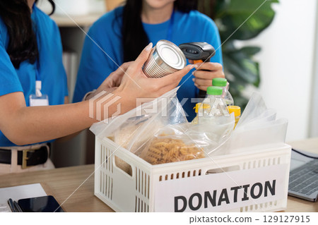 Volunteers checking canned goods for donation, community service Volunteers checking canned goods for donation, community service 129127915