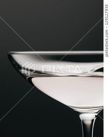Minimalist detail of a transparent glass with drink and dark backdrop 129127938