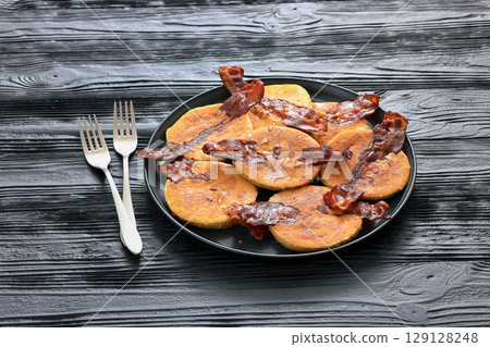 bacon pancakes drizzled with sirup on a plate bacon pancakes drizzled with sirup on a plate 129128248