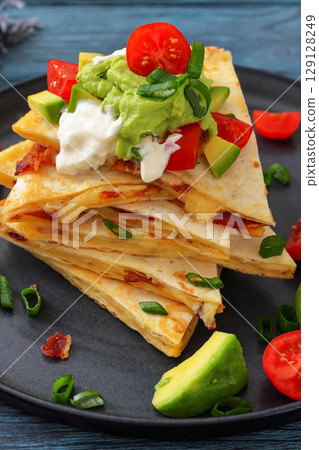 quesadilla with cheese, bacon, avocado on a plate quesadilla with cheese, bacon, avocado on a plate 129128249