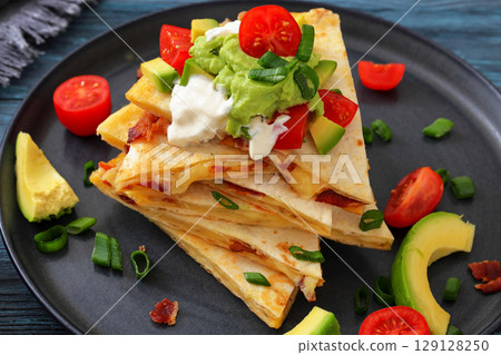 quesadilla with cheese, bacon, avocado on a plate 129128250
