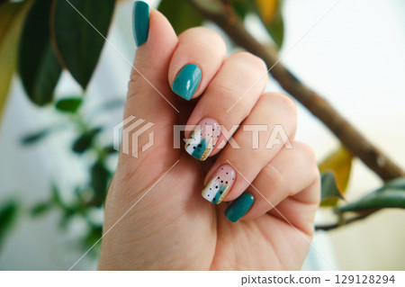 Female hands with green nail design. 129128294