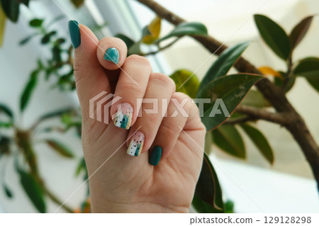 Female hands with green nail design. Female hands with green nail design. 129128298