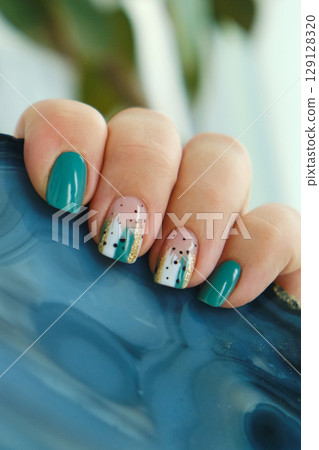 Female hands with green nail design. Female hands with green nail design. 129128320