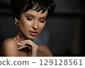 Close-up portrait of a short haired sensual Caucasian young woman with closed eyes. Skin care concept. Photo with copy space over dark background. 129128561