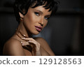 Close-up portrait of a sensual Caucasian young woman. Young sexy short haired brunette woman looking at camera. Skin care concept. Photo with copy space over dark background. 129128563