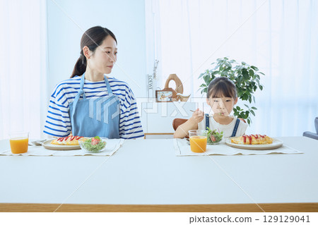 母女倆看著孩子的飯菜，享用溫暖的早餐 129129041