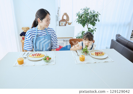 母女倆看著孩子的飯菜，享用溫暖的早餐 129129042