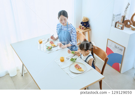 母女倆看著孩子的飯菜，享用溫暖的早餐 129129050