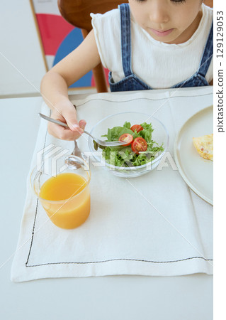 一個女孩吃沙拉的健康用餐場景 一個女孩吃沙拉的健康用餐場景 129129053