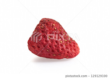 Close-up of a single freeze-dried strawberry against a white background 129129100