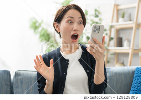 A woman surprised to see a smartphone A woman surprised to see a smartphone 129129809